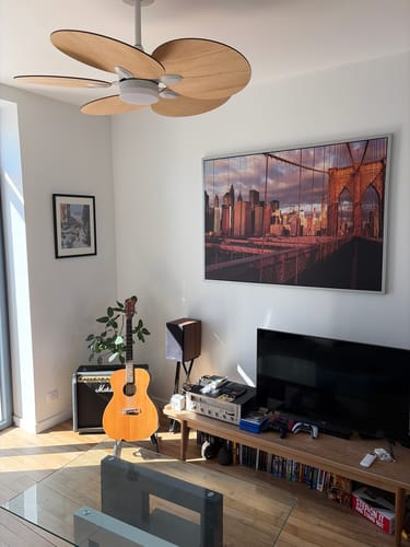 Customer's Lotus teinté Chêne ventilateur de plafond en bois installé au milieu d'un salon chaleureux.