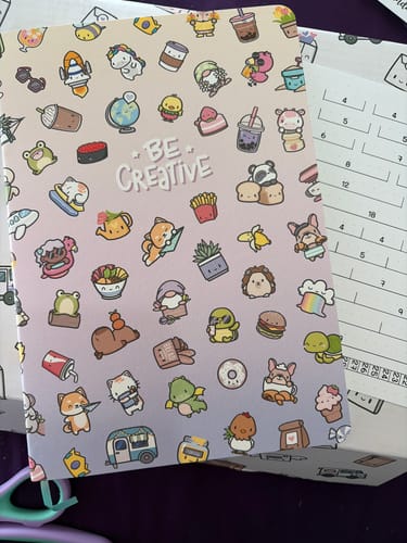 Customer's Starter Journal, a softcover notebook with a light pink cover featuring colorful, cute doodle patterns.