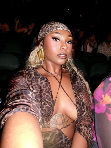 Customer's leopard print Chiffon Head Scarf worn tied around the head in a dimly lit setting.
