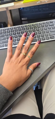 Customer's hand wearing three gold-toned rings from the Summer Box Packaging set.