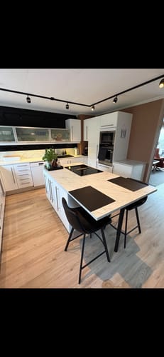 Customer's kitchen with 10-pk Sort fiskebein selvklebende veggfliser installed as a stylish backsplash.