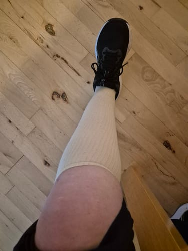 Anmelders beige støttestrømper fra Diasocks på benet, set oppefra mens de bærer en sort sko.