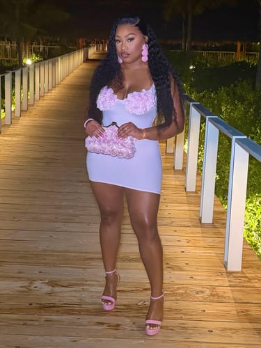 Customer's Naked Rose Tank Mini Dress with rosette detail, worn on a wooden walkway at night.