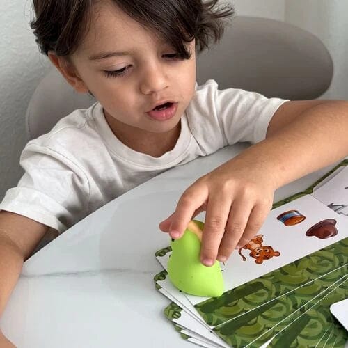 Child tapping a Rexi word card at the table.