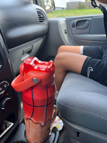 Customer's basketball-themed Bottle Buddy 32oz water bottle in a vehicle cup holder.