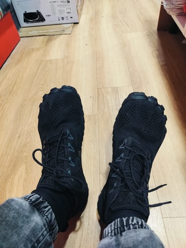 Customer's black Smart I Pro barefoot shoes worn on feet while indoors.