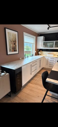 Customer's kitchen view featuring the installed black herringbone adhesive tiles.