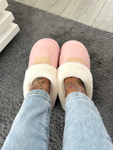 Customer's roze Happy Flops pantoffels met zachte witte voering, gedragen aan de voeten van de reviewer.