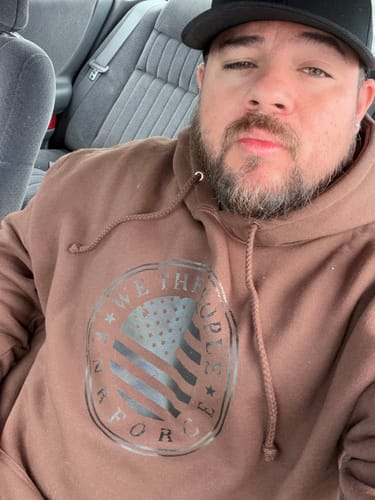 Customer's ENR#89 Exclusive Mystery Box brown hooded sweatshirt with graphic print, worn in a car.