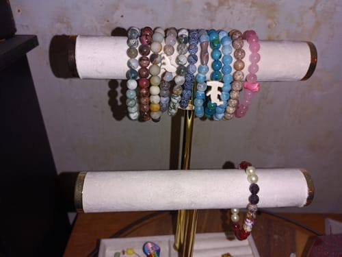 Customer's collection of colorful beaded Roam Bracelets displayed on a jewelry stand.