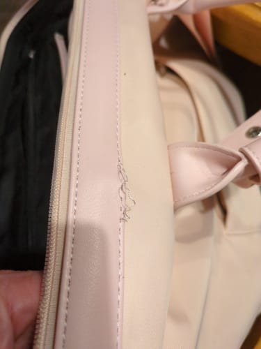 Reviewer's light pink Weekender Bag showing frayed stitching along the seam.