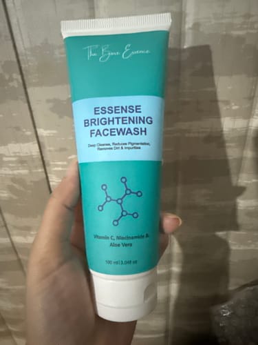 Customer's hand holding a tube of Essense Brightening Facewash, part of their lip care set.