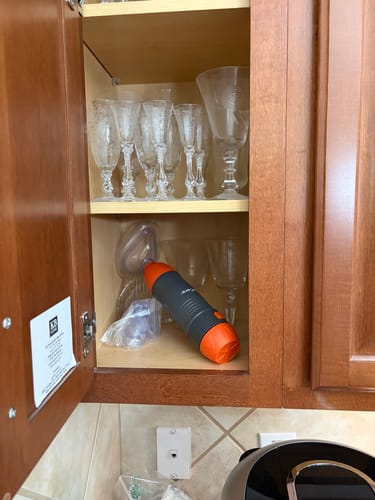 Reviewer's Adult and Child Mask set stored on a kitchen cabinet shelf behind glassware.