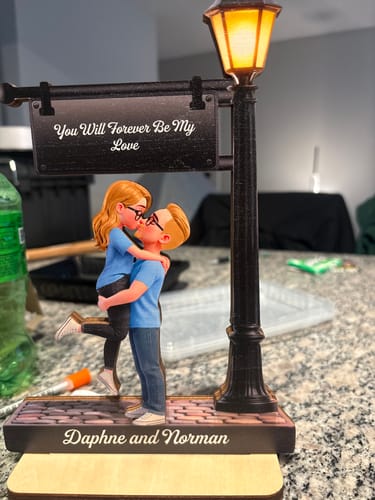 Customer's Personalized Wooden Plaque featuring a couple under a glowing lamp post, engraved with Daphne and Norman