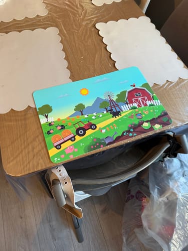 Customer's Bordbrikke bondegård med fargerikt traktor- og dyremotiv plassert på et trebord.
