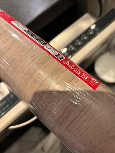 Customer's Oak minimal kontaktplast rull med trestruktur, sett på nært hold i innpakning.