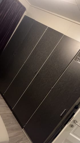 Customer's wardrobe doors covered in Skifer matt kontaktplast with a textured dark gray finish.
