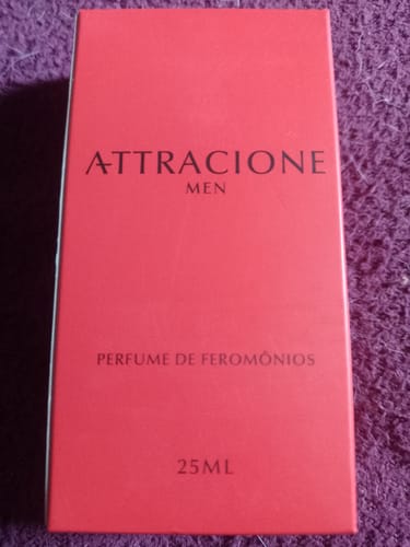 Customer's Attracione Men perfume box in bright red packaging with visible label, placed on a textured surface.