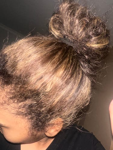 Reviewer's hair in a high bun after using Kérastase Resistance Masque Thérapiste to smooth and hydrate damaged strands.