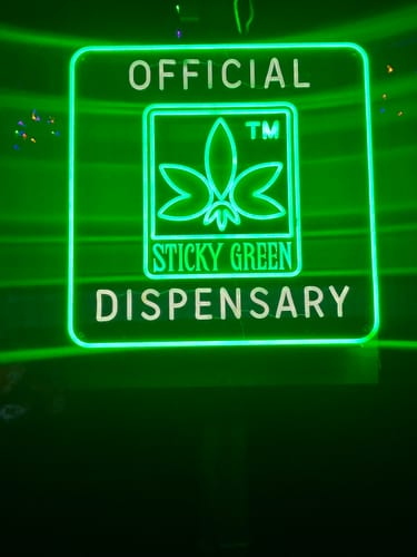Customer's green Sticky Green Neon Sign glowing in a dark setting