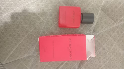 Customer's Attracione Men perfume bottle and its red packaging box on a textured surface.