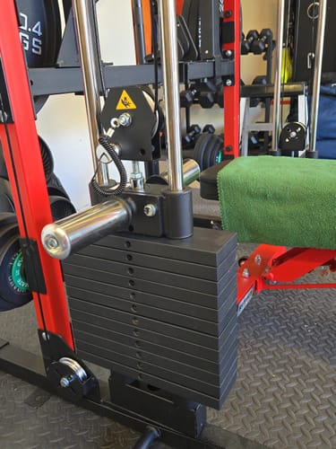 Customer's RitFit WSM1 Weight Stack set installed on a red Smith machine in a home gym.