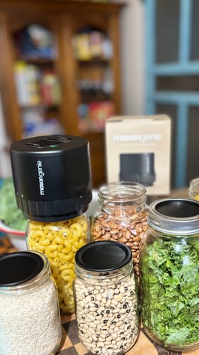 Customer's Mason Genie Vacuum Sealer Kit sealing multiple glass jars filled with dry goods and kale in a pantry.