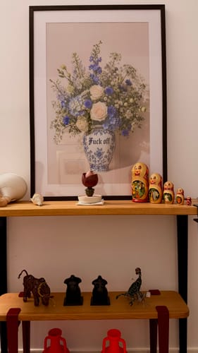 Customer's framed Boundaries art print hanging above a wooden shelf featuring decorative figurines.