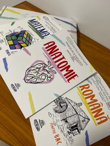 Customer's Pachet Bacalaureat books for Romanian, Math, and Anatomy placed on a wooden surface.