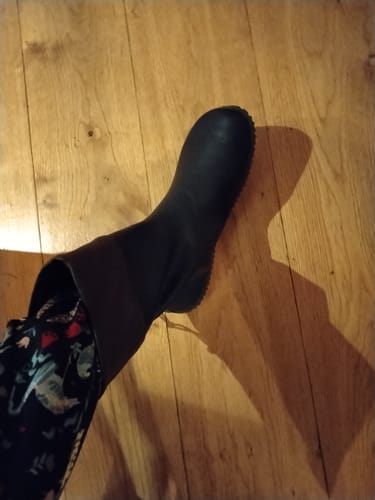 Customer's black Brisk Ⅰ barefoot rain boot worn mid-calf on a wooden floor.
