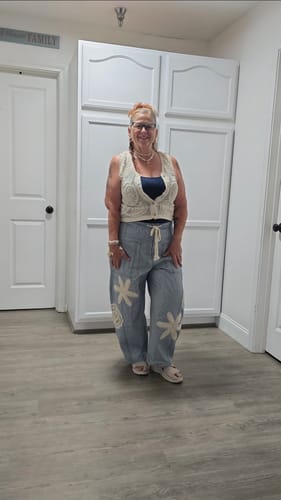 Customer's blue and white striped drawstring pants with crochet floral appliques, worn with a sleeveless top.