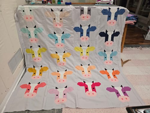 Customer's Annabelle Precut Quilt Kit featuring a completed quilt with a grid of colorful cow block patterns.