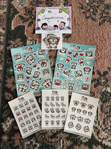 Reviewer's My Otter Half sticker collection featuring five sheets and one die cut, laid out on a patterned rug.