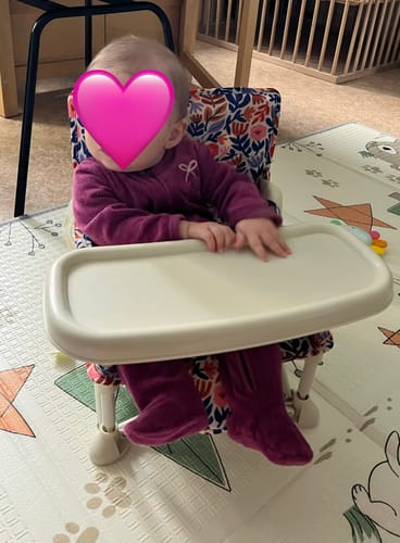 Customer's Willow baby chair with floral fabric sitting on a play mat with a baby.