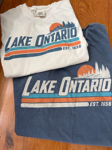 Customer's white and blue Lake Ontario Retro Stripe T-Shirts showing the vintage lighthouse graphic.