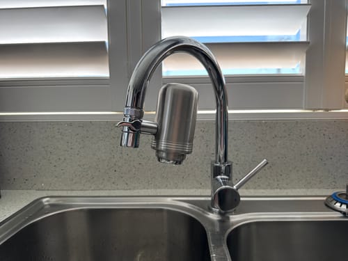 Customer's BlissfulHome Replacement Tap Water Filter installed on a shiny silver kitchen faucet.