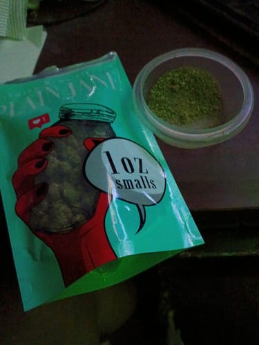 Customer's Black Mamba THCA flower packaging next to a small bowl of finely ground, greenish herb.