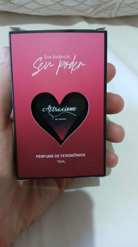Customer's Attracione Sensual perfume box held in hand, showing a pink and black heart design.