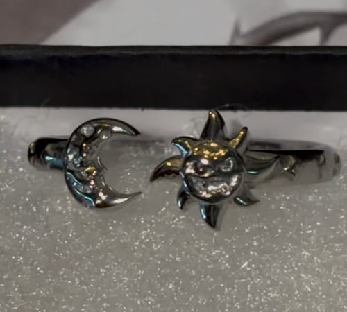 Customer's Mini Rings featuring a detailed sun and crescent moon design, resting in a padded ring box.