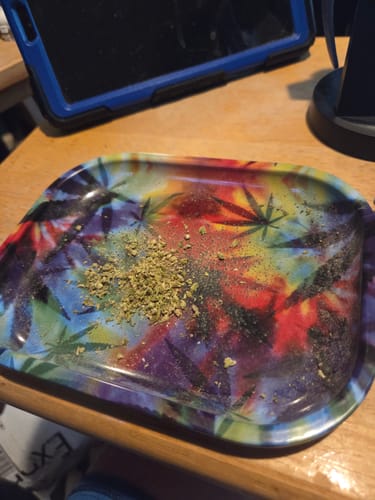 Customer's Purple Punch ground cannabis on a colorful, cannabis-themed rolling tray.
