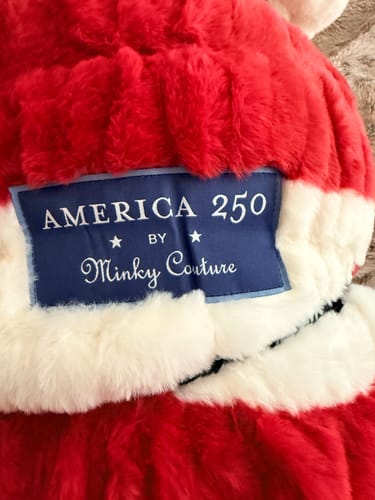 Customer's close-up of the Hugs Flag Blanket America 250 Minky Couture label