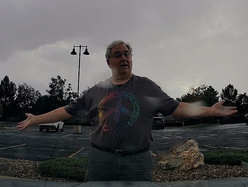 Reviewer standing outdoors wearing a baggy grey Peace Sign T-Shirt with a colorful graphic.