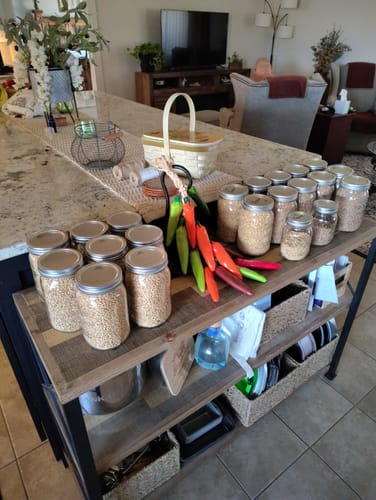 Customer's Mason Genie Vacuum Sealer Kit used on many glass jars of wheat berries and baking supplies on a kitchen island.