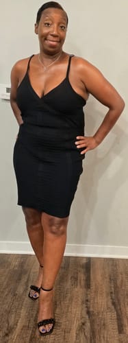 Customer standing wearing a black dress, demonstrating healthy skin glow from Body Magic Chlorophyll Pill.