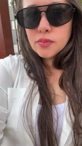 Customer's Milagres sunglasses, with black frames, being worn by a person.