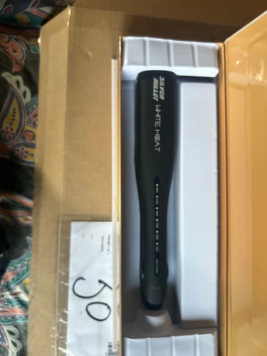 Customer's Silver Bullet White Heat Max straightener partially unboxed, showing the black device inside its packaging.