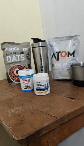 Customer's Wellcore Creatine Monohydrate bottle on a wooden table with other protein products.