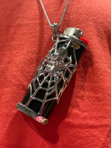 Customer's SPIDER LIGHTER CASE, a silver spider and web design on a black lighter, worn on a metal chain.