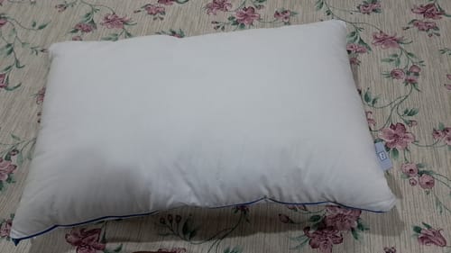 Customer's Flo Adjustable Pillow on a floral patterned bedspread