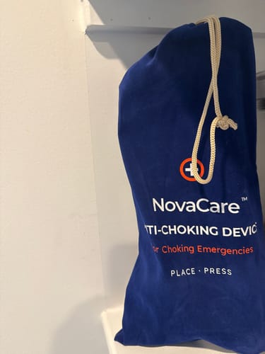 Customer's blue NovaCare Anti-Choking Device storage bag with white drawstring and branded text.